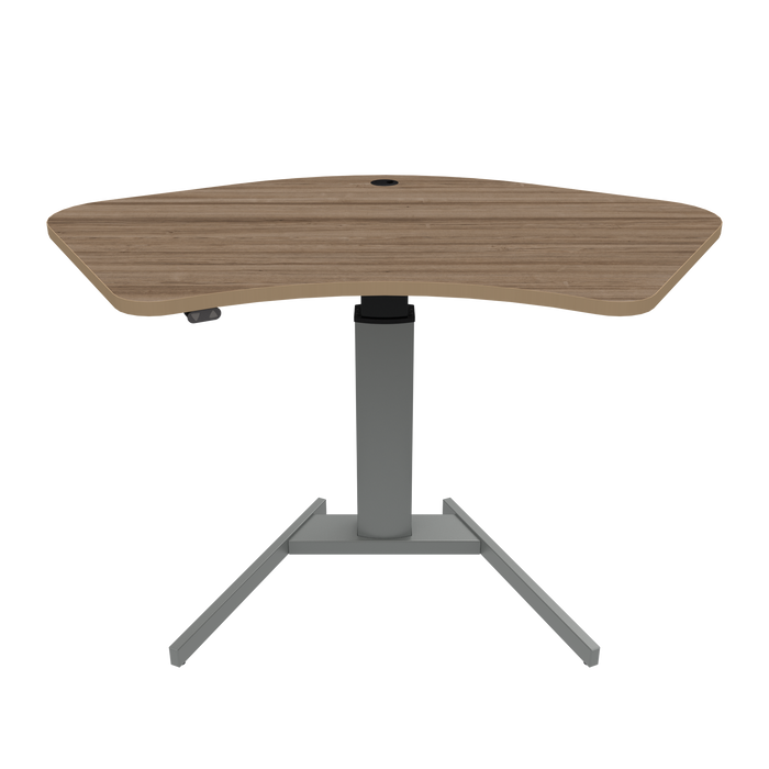 ConSet brand stand-up desk featuring a maple wood finish tabletop with an ergonomic curve design, supported by a single, sturdy silver steel column and a T-shaped base.