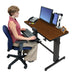 Ergotron WorkFit-D Sit-Stand Desk Walnut with seated person