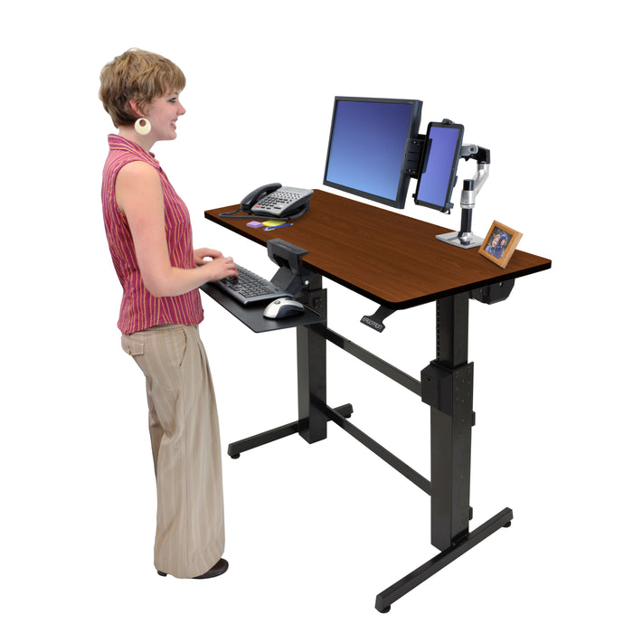 Ergotron WorkFit-D Sit-Stand Desk Walnut with person standing
