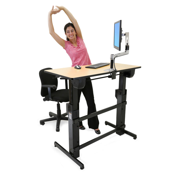 Ergotron WorkFit-D Sit-Stand Desk Birch with person standing and stretching